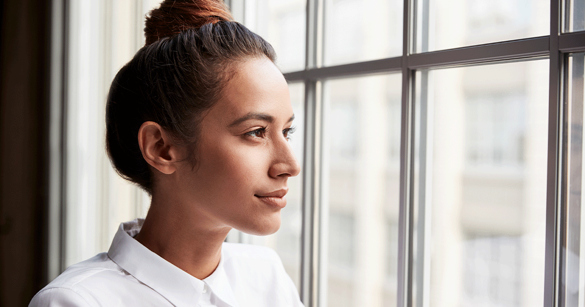 Woman looking out a window while preparing mentally and physically for childbirth.